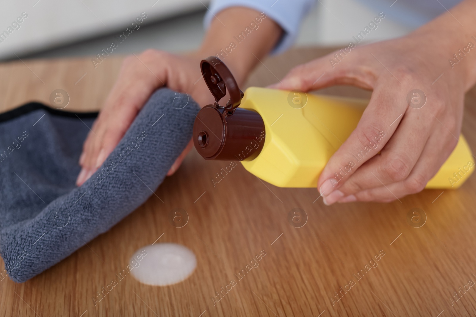 Photo of Woman polishing wooden table at home, closeup