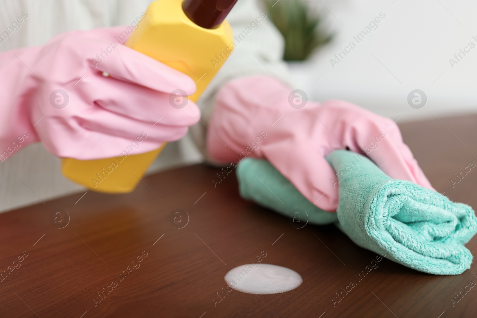 Photo of Woman polishing wooden table at home, closeup