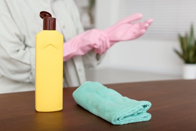 Photo of Woman polishing wooden table at home, closeup