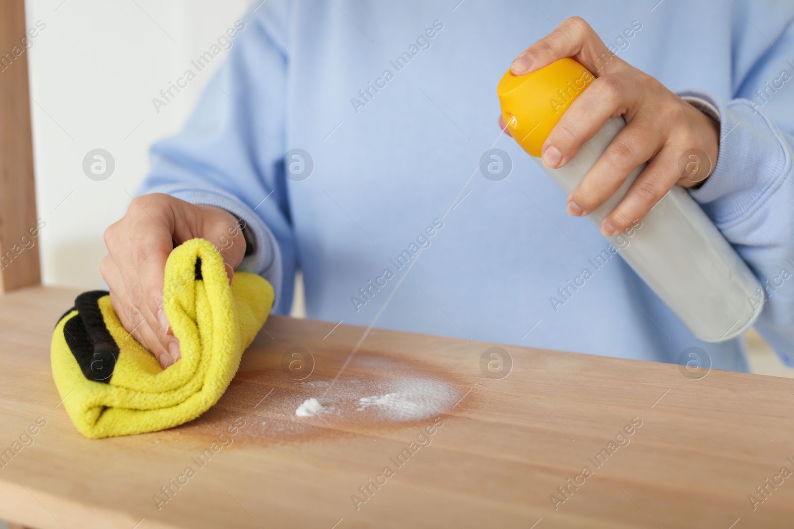 Photo of Woman polishing wooden table at home, closeup