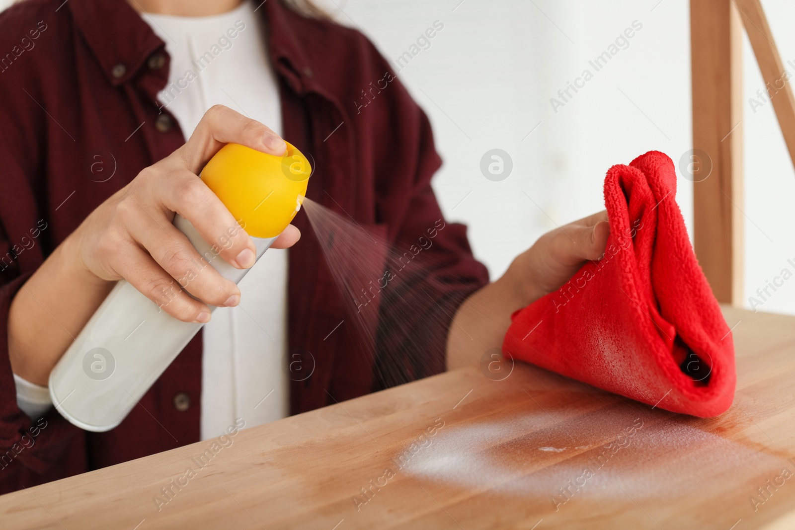 Photo of Woman polishing wooden table at home, closeup