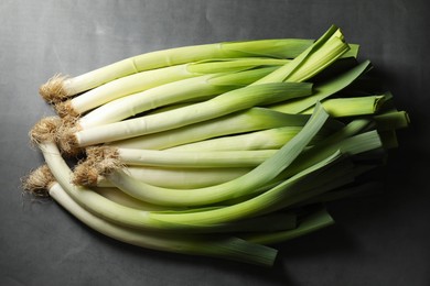 Photo of Fresh green leeks on grey table, top view