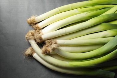 Photo of Fresh green leeks on grey table, top view