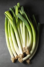 Photo of Fresh green leeks on grey table, top view