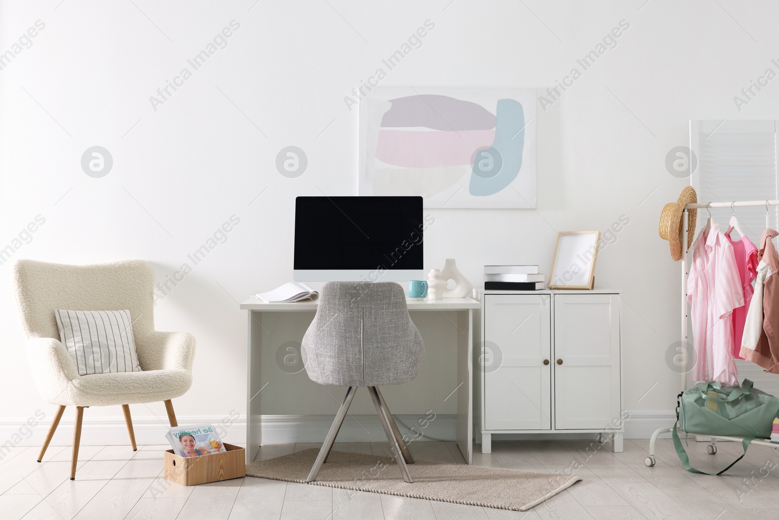 Photo of Home office. Comfortable workplace near white wall. Desk with computer and other furniture in room