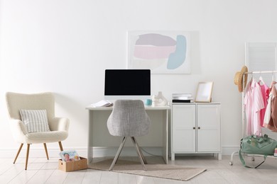 Photo of Home office. Comfortable workplace near white wall. Desk with computer and other furniture in room