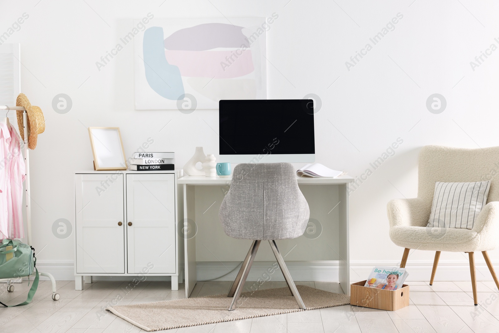 Photo of Home office. Comfortable workplace near white wall. Desk with computer and other furniture in room