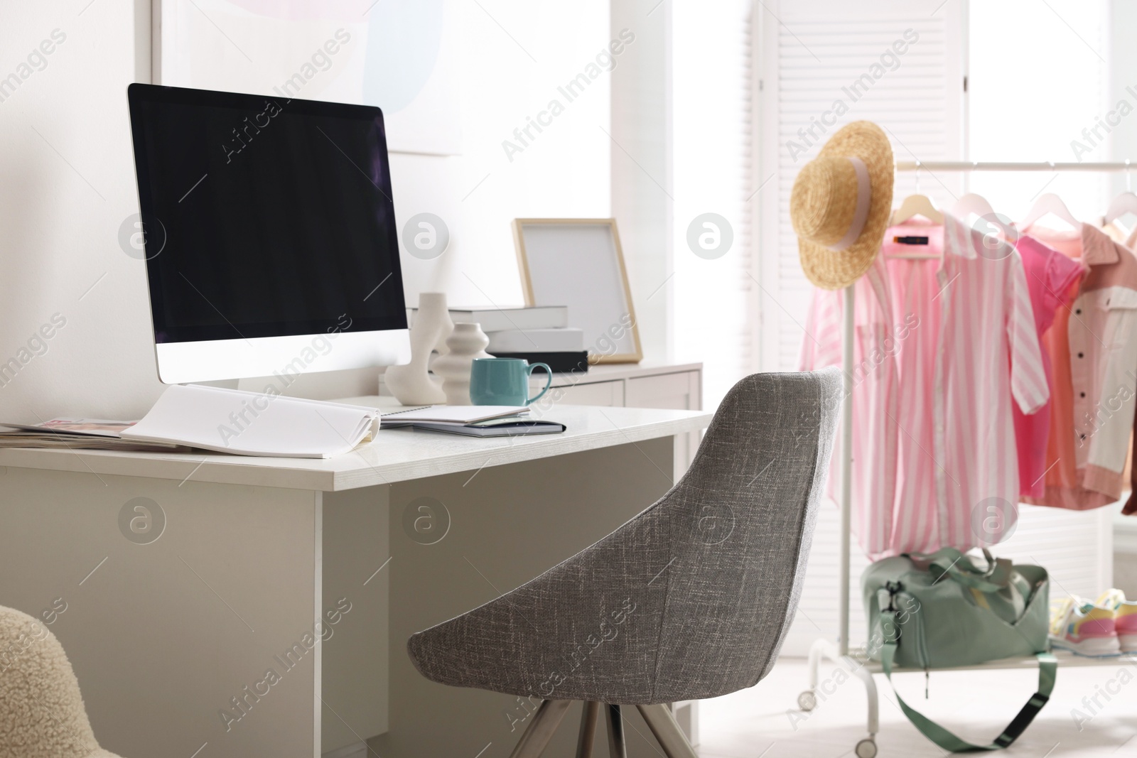 Photo of Home office. Comfortable workplace near white wall. Desk with computer and other furniture in room