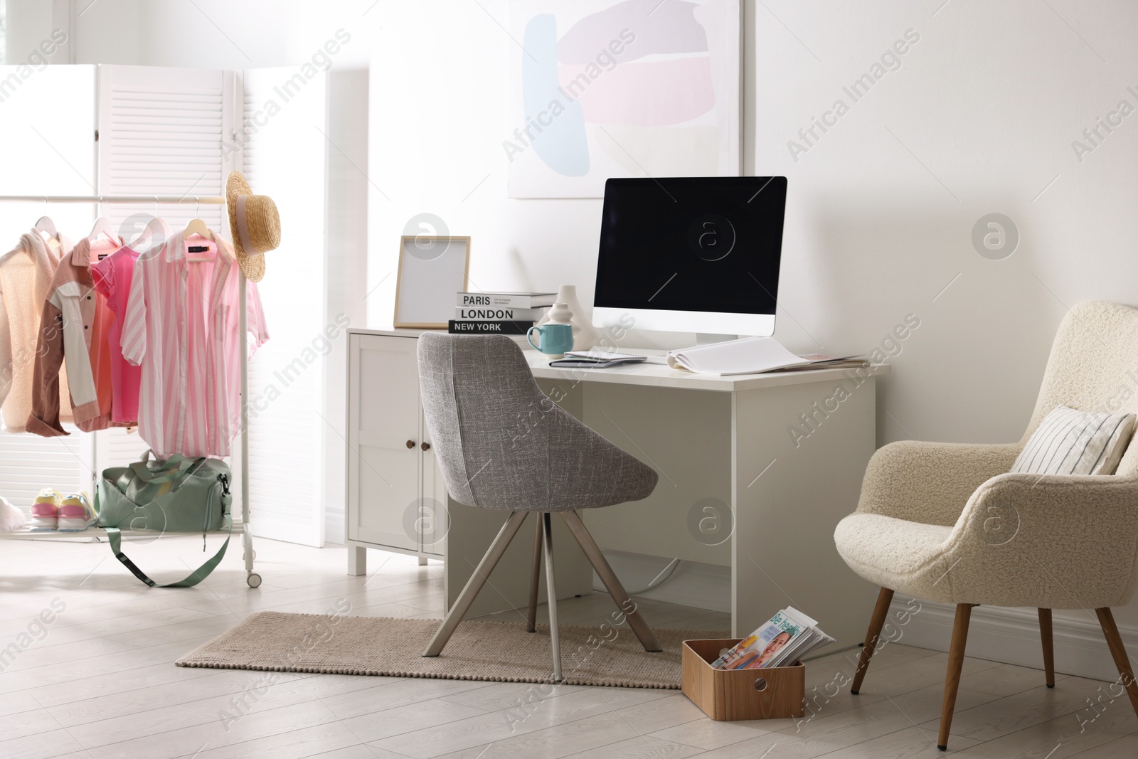 Photo of Home office. Comfortable workplace near white wall. Desk with computer and other furniture in room