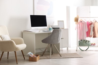 Photo of Home office. Comfortable workplace near white wall. Desk with computer and other furniture in room