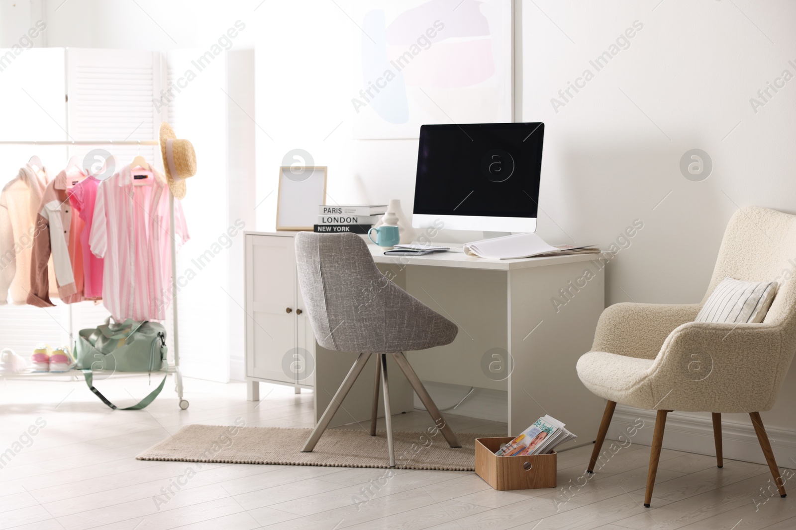 Photo of Home office. Comfortable workplace near white wall. Desk with computer and other furniture in room