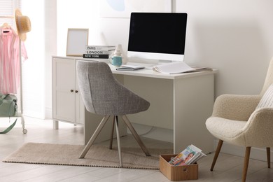 Photo of Home office. Comfortable workplace near white wall. Desk with computer and other furniture in room