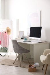 Photo of Home office. Comfortable workplace near white wall. Desk with computer and other furniture in room