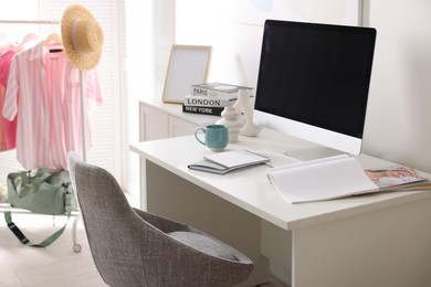 Photo of Home office. Comfortable workplace near white wall. Desk with computer and other furniture in room