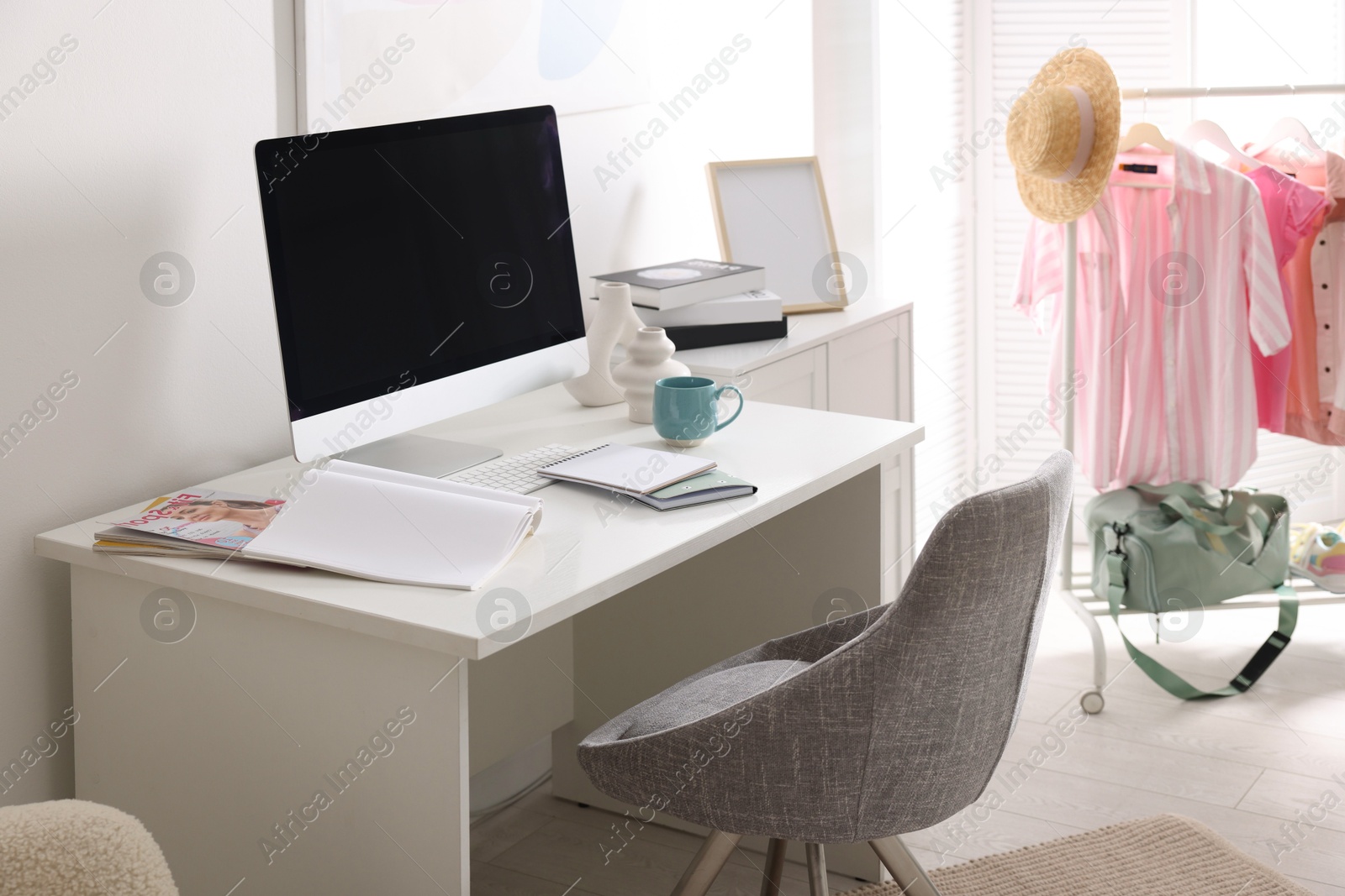 Photo of Home office. Comfortable workplace near white wall. Desk with computer and other furniture in room