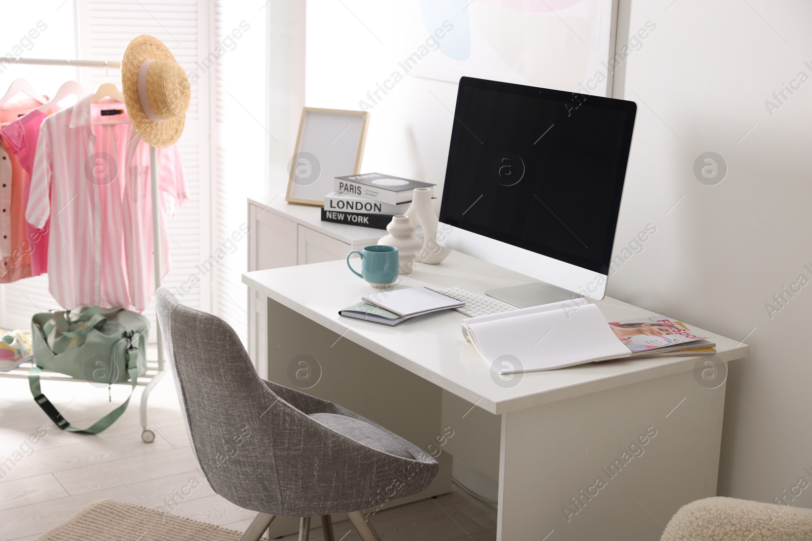 Photo of Home office. Comfortable workplace near white wall. Desk with computer and other furniture in room