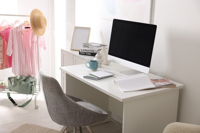 Photo of Home office. Comfortable workplace near white wall. Desk with computer and other furniture in room