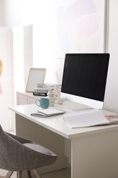 Photo of Home office. Comfortable workplace near white wall. Desk with computer and other furniture in room