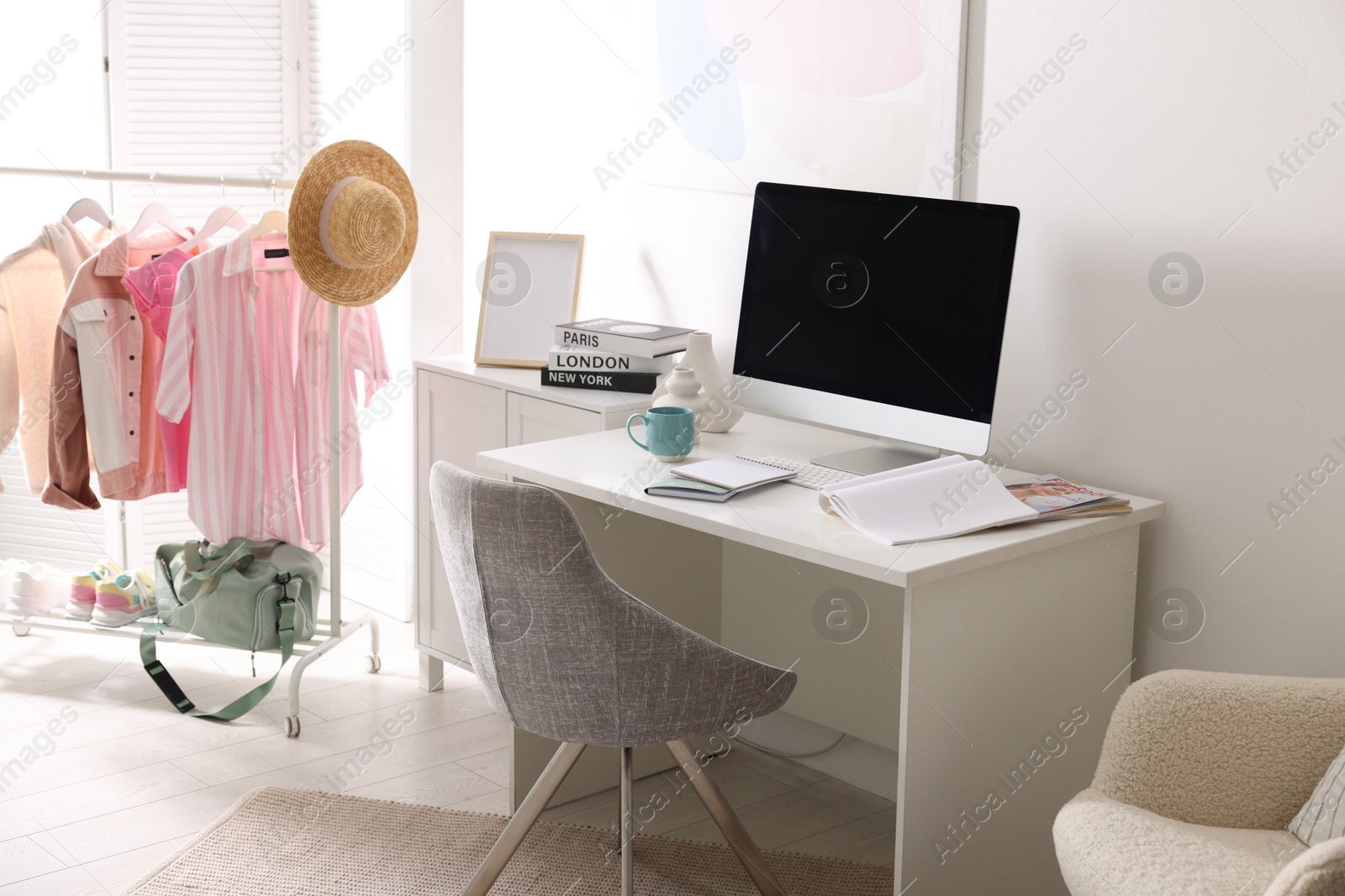 Photo of Home office. Comfortable workplace near white wall. Desk with computer and other furniture in room