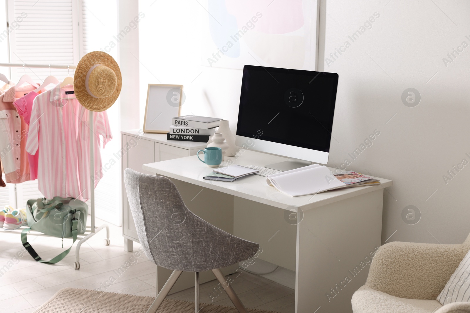 Photo of Home office. Comfortable workplace near white wall. Desk with computer and other furniture in room