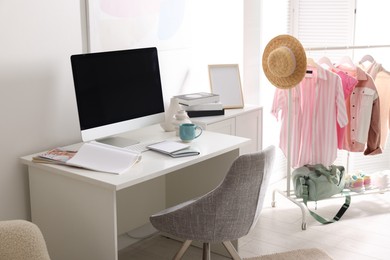 Photo of Home office. Comfortable workplace near white wall. Desk with computer and other furniture in room