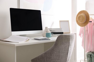 Photo of Home office. Comfortable workplace near white wall. Desk with computer and other furniture in room