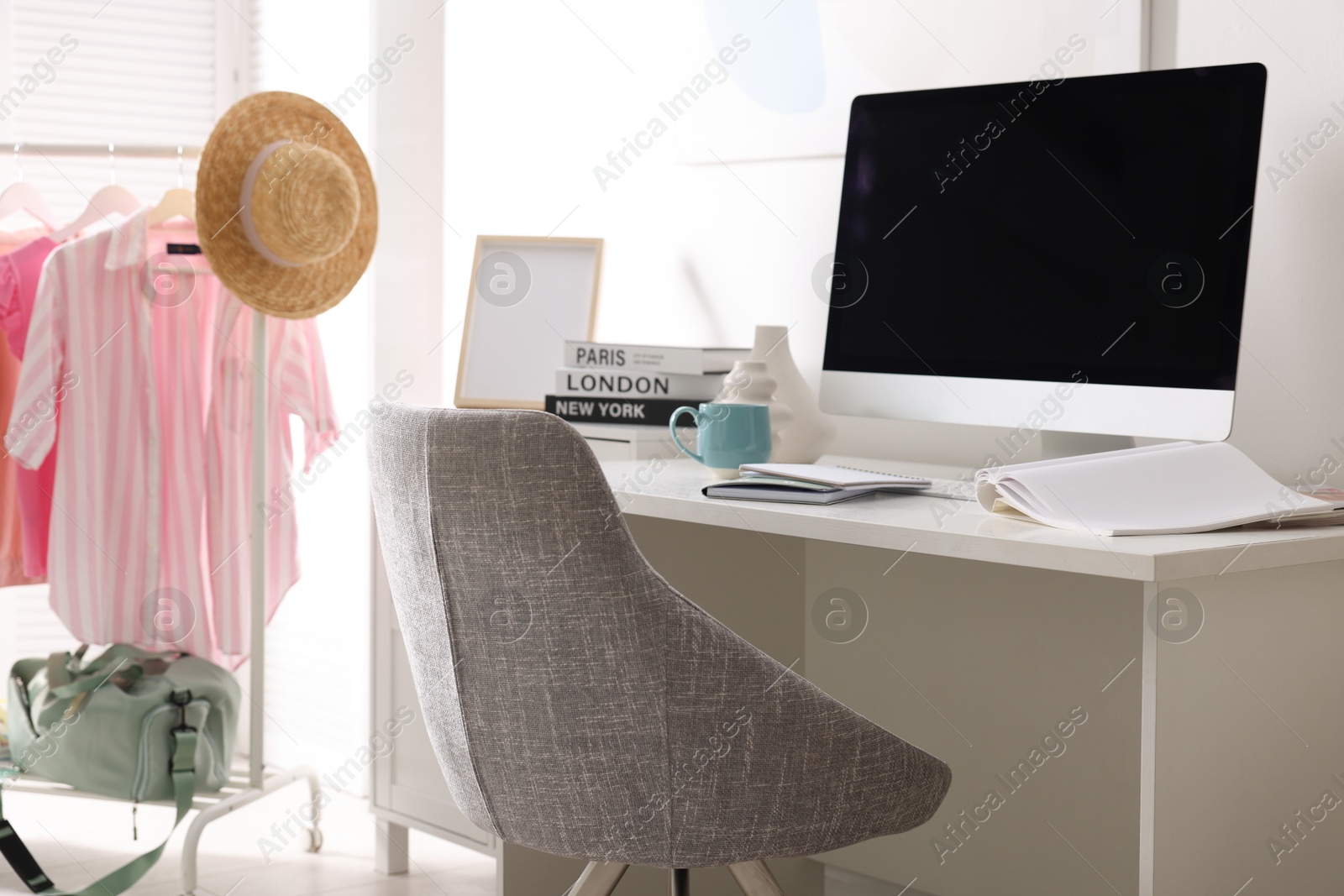 Photo of Home office. Comfortable workplace near white wall. Desk with computer and other furniture in room