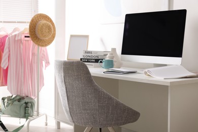 Photo of Home office. Comfortable workplace near white wall. Desk with computer and other furniture in room