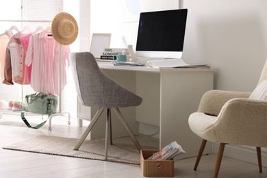 Photo of Home office. Comfortable workplace near white wall. Desk with computer and other furniture in room