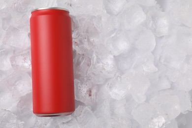 Photo of Refreshing drink in can on ice cubes, top view. Space for text