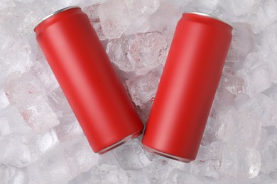 Photo of Refreshing drinks in cans on ice cubes, top view