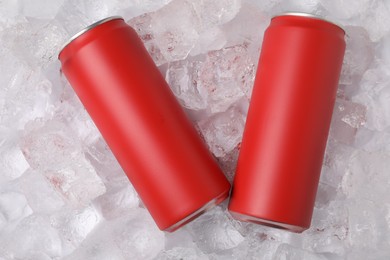 Photo of Refreshing drinks in cans on ice cubes, top view