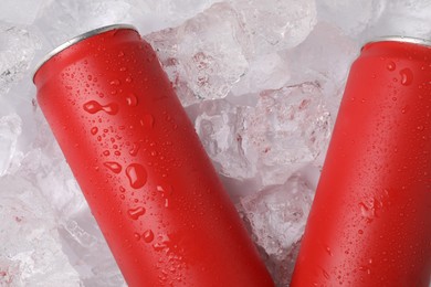 Photo of Refreshing drinks in cans on ice cubes, top view