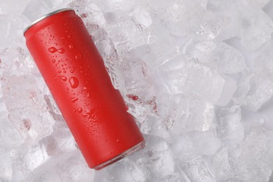 Photo of Refreshing drink in can on ice cubes, top view. Space for text
