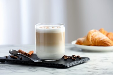 Photo of Tasty latte macchiato in glass on marble table, closeup. Coffee drink