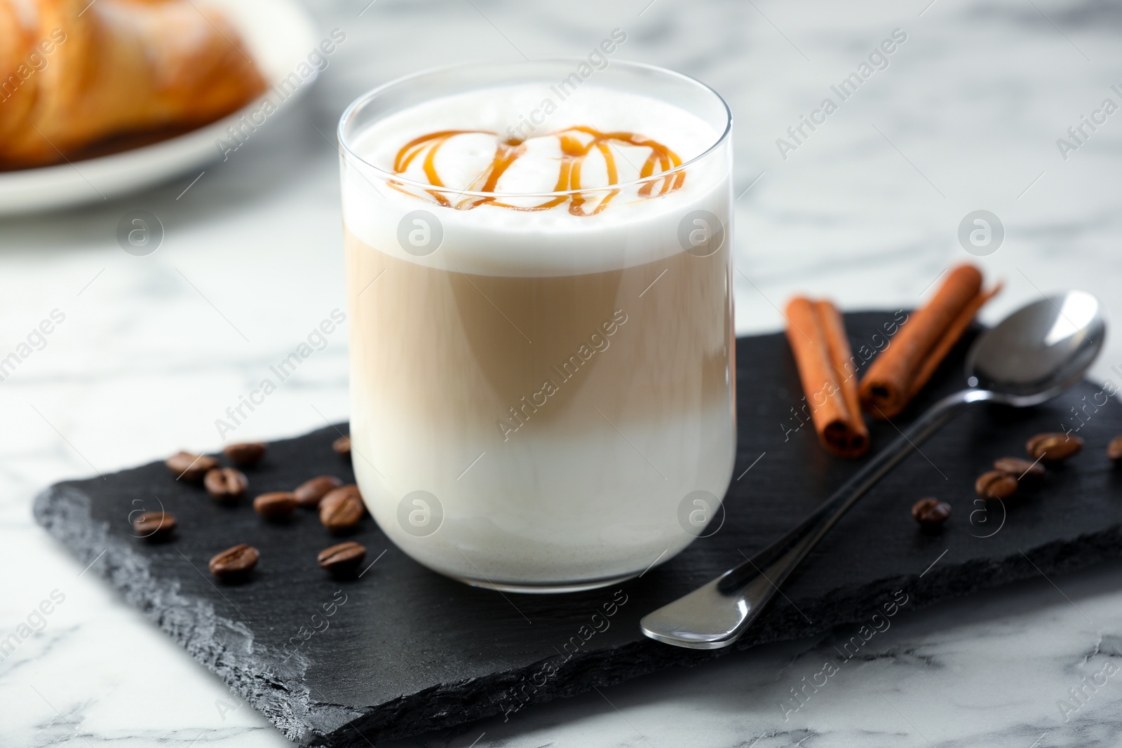 Photo of Tasty latte macchiato in glass on marble table, closeup. Coffee drink