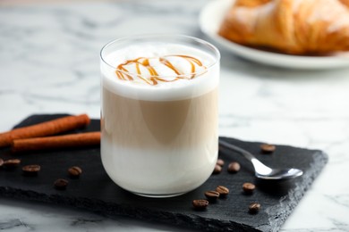 Photo of Tasty latte macchiato in glass on marble table, closeup. Coffee drink