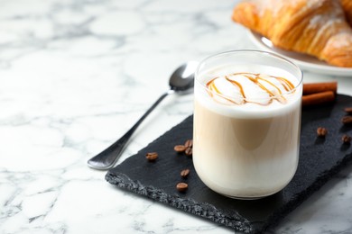 Photo of Tasty latte macchiato in glass on marble table, space for text. Coffee drink