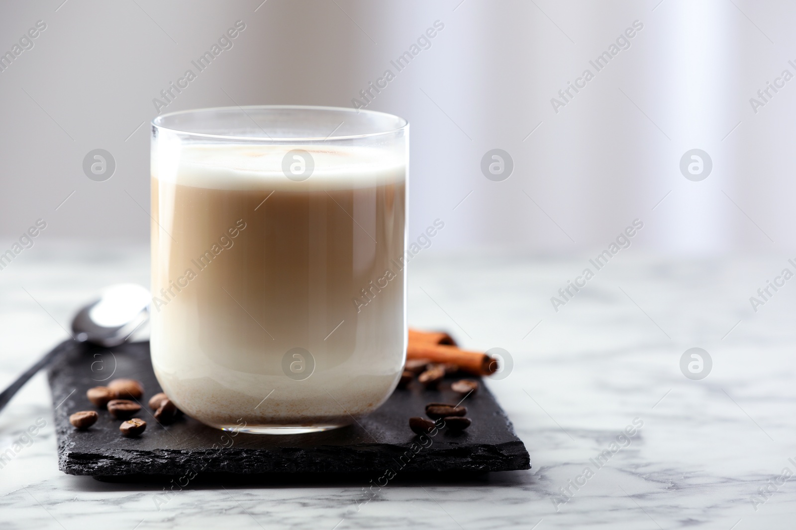 Photo of Tasty latte macchiato in glass on marble table, space for text. Coffee drink