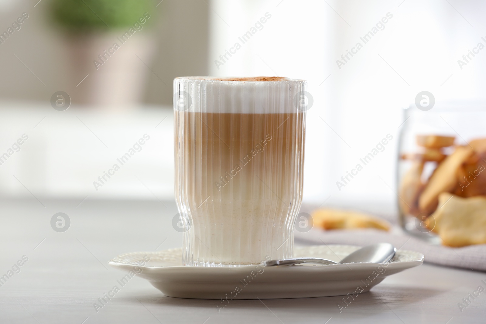 Photo of Tasty latte macchiato in glass on white table, closeup. Coffee drink