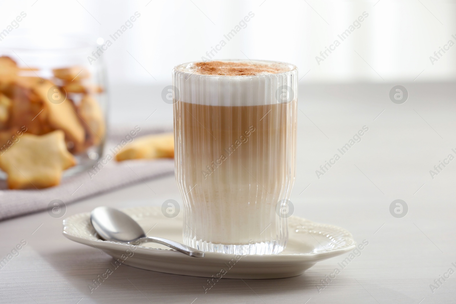 Photo of Tasty latte macchiato in glass on white table, closeup. Coffee drink