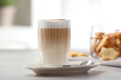 Photo of Tasty latte macchiato in glass on white table, closeup. Coffee drink