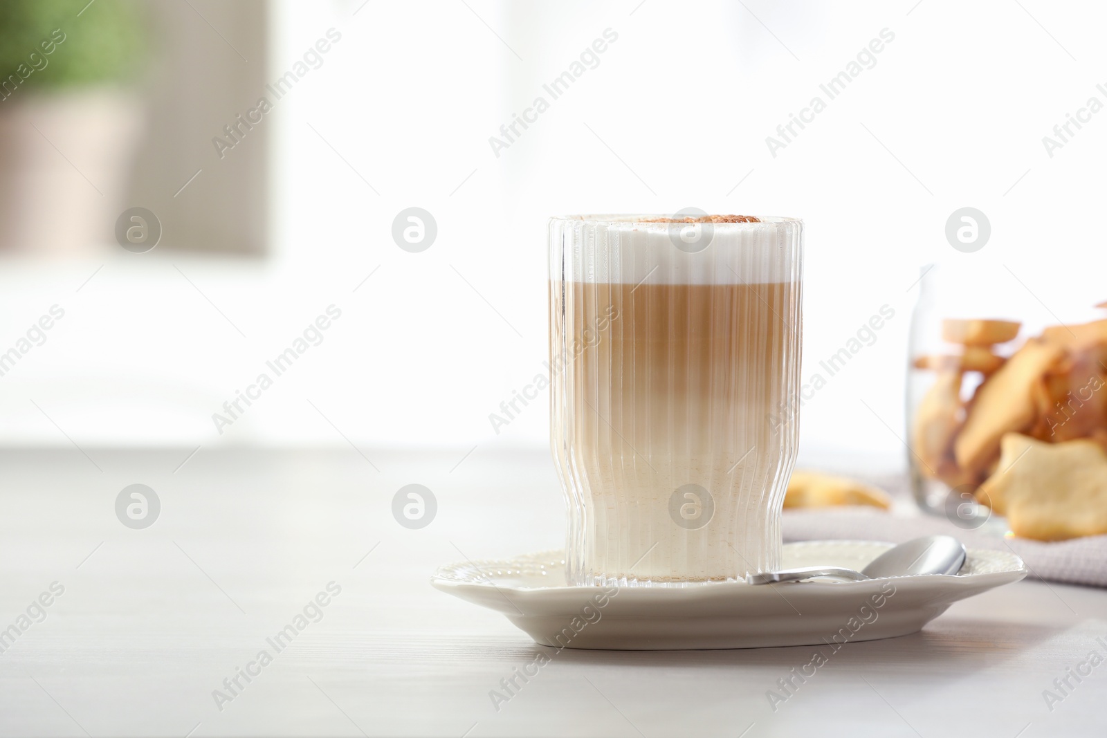 Photo of Tasty latte macchiato in glass on white table, space for text. Coffee drink