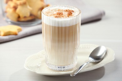 Photo of Tasty latte macchiato in glass on white table, closeup. Coffee drink