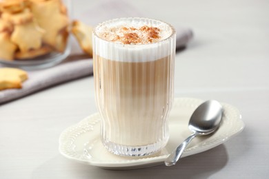 Photo of Tasty latte macchiato in glass on white table, closeup. Coffee drink