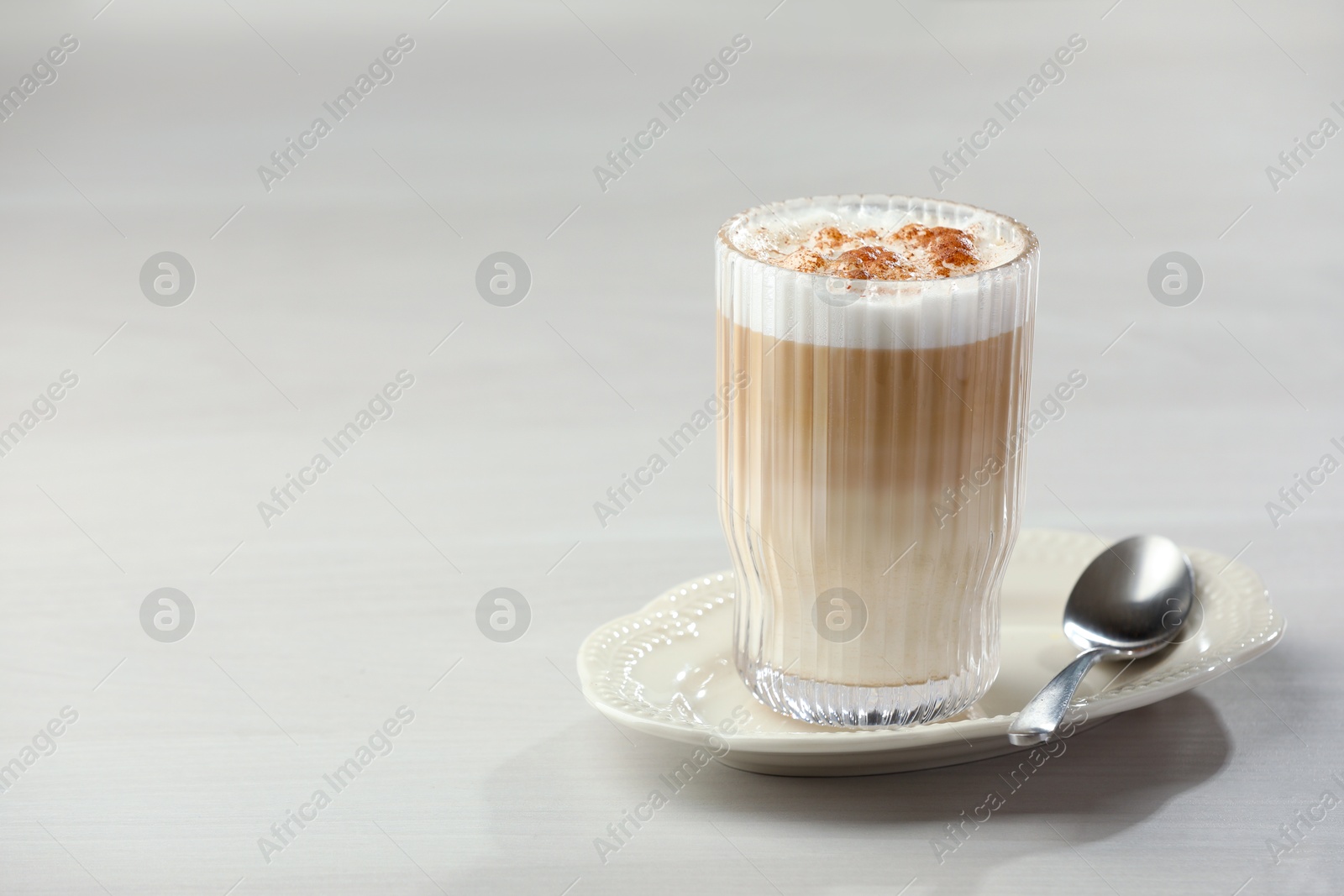 Photo of Tasty latte macchiato in glass on white table, space for text. Coffee drink