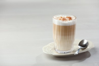 Photo of Tasty latte macchiato in glass on white table, space for text. Coffee drink