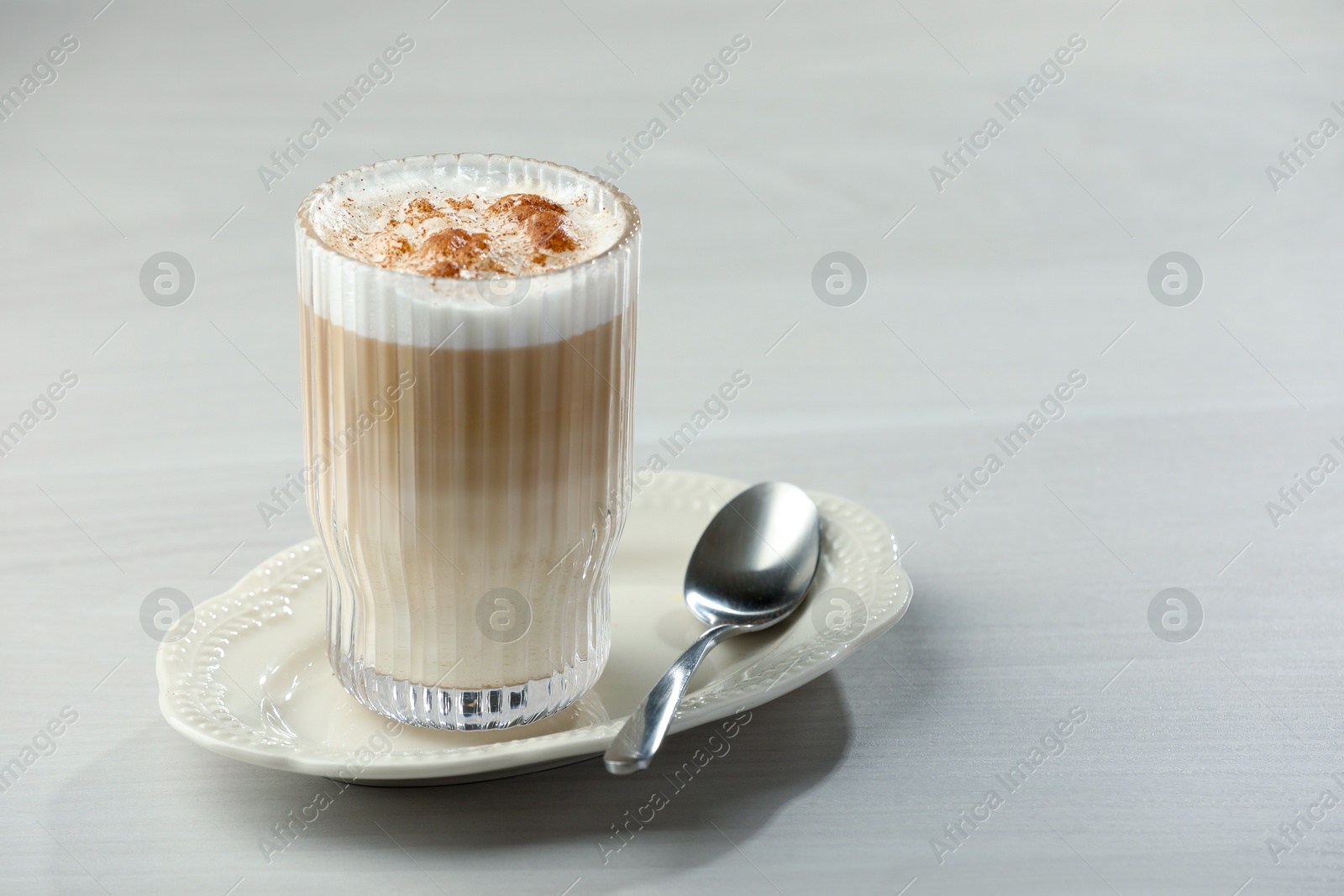 Photo of Tasty latte macchiato in glass on white table, space for text. Coffee drink