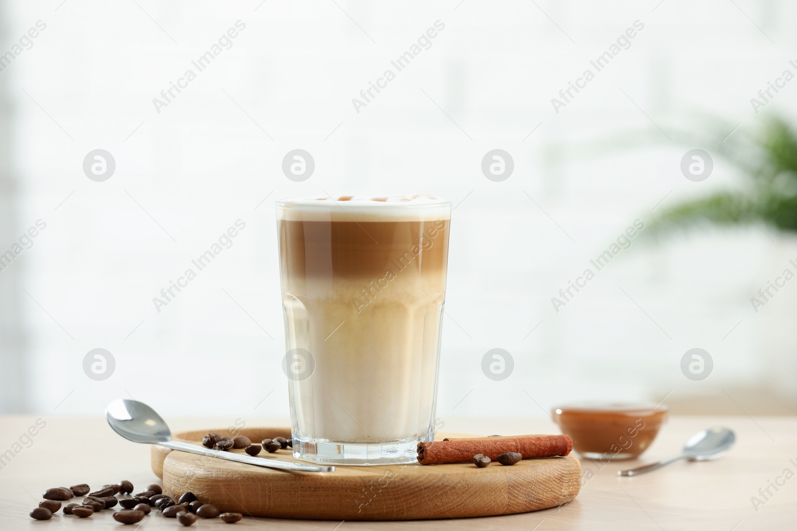 Photo of Tasty latte macchiato in glass on wooden table