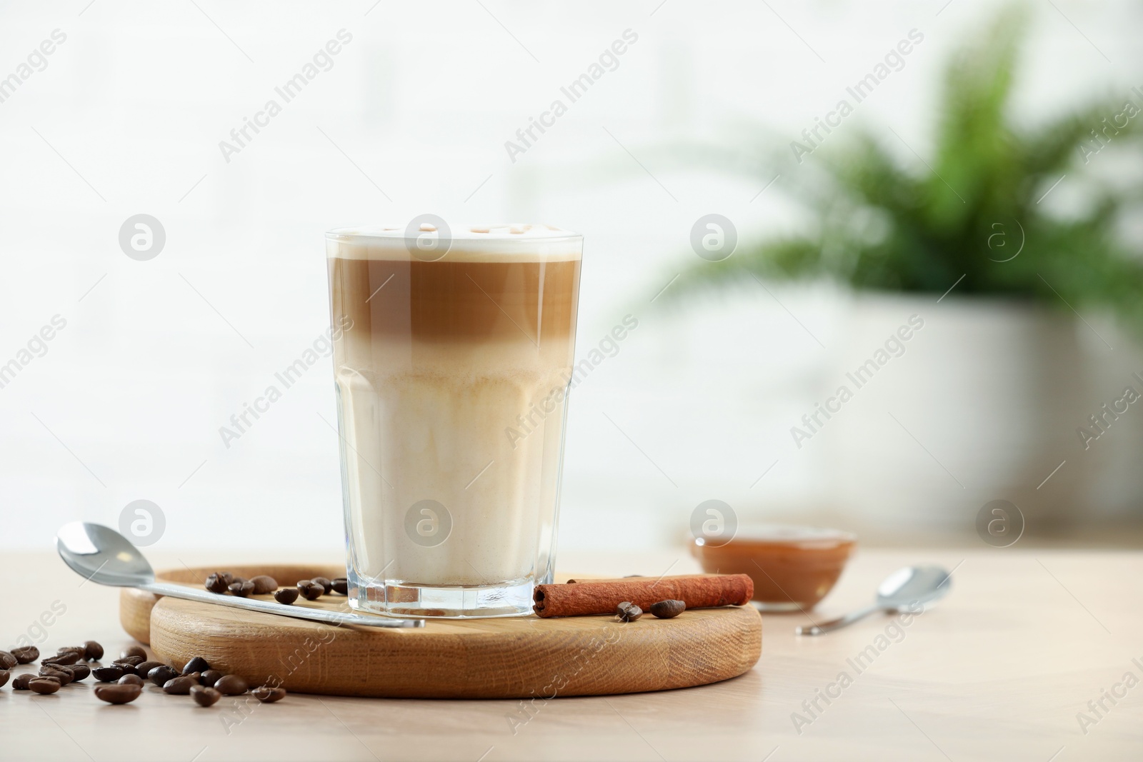 Photo of Tasty latte macchiato in glass on wooden table, space for text